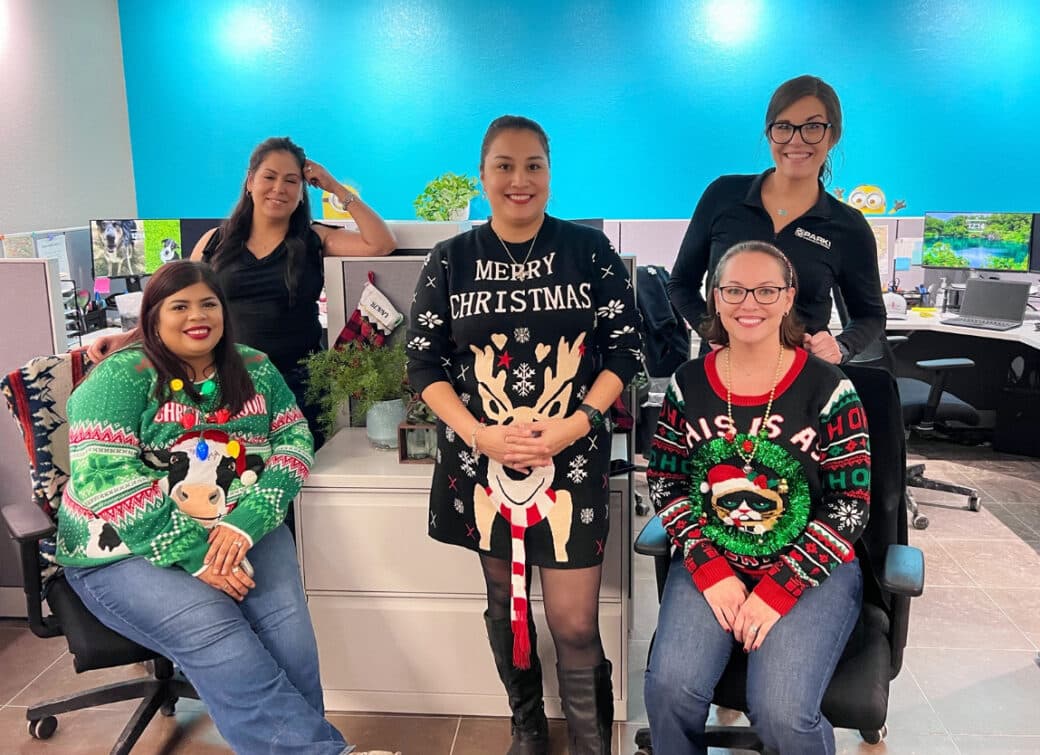 Women in holiday sweaters in the office
