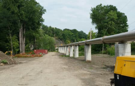 elevated steel pipeline through trees