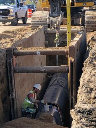 racine water transmission man working on pipe in trench