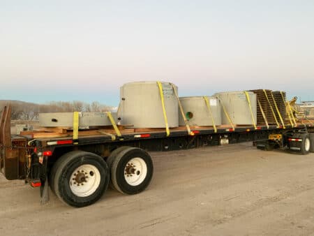 flat bed truck transporting manholes