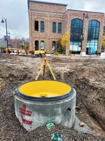 Perfect Lined Manhole being installed in ground in front of brick building