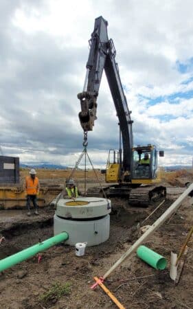 crane and construction crew installing Perfect Lined Manhole