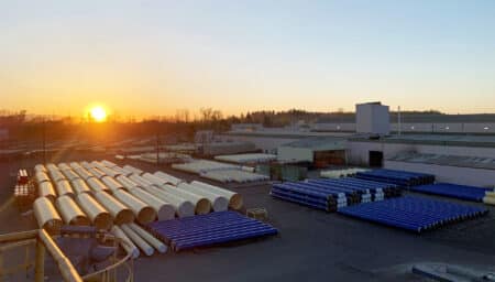 Aerial view of steel pipe in the Portland Plant yard at sunrise