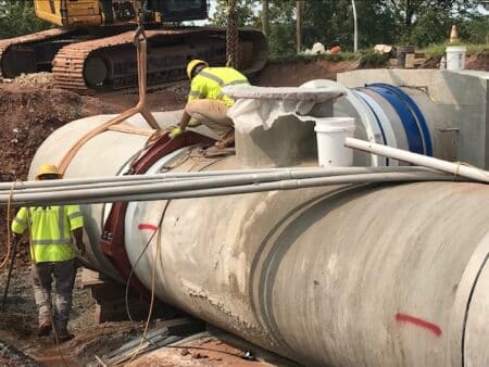 The team uses a Victaulic W77 connection joint (provided by Northwest Pipe) to secure the two pipes.