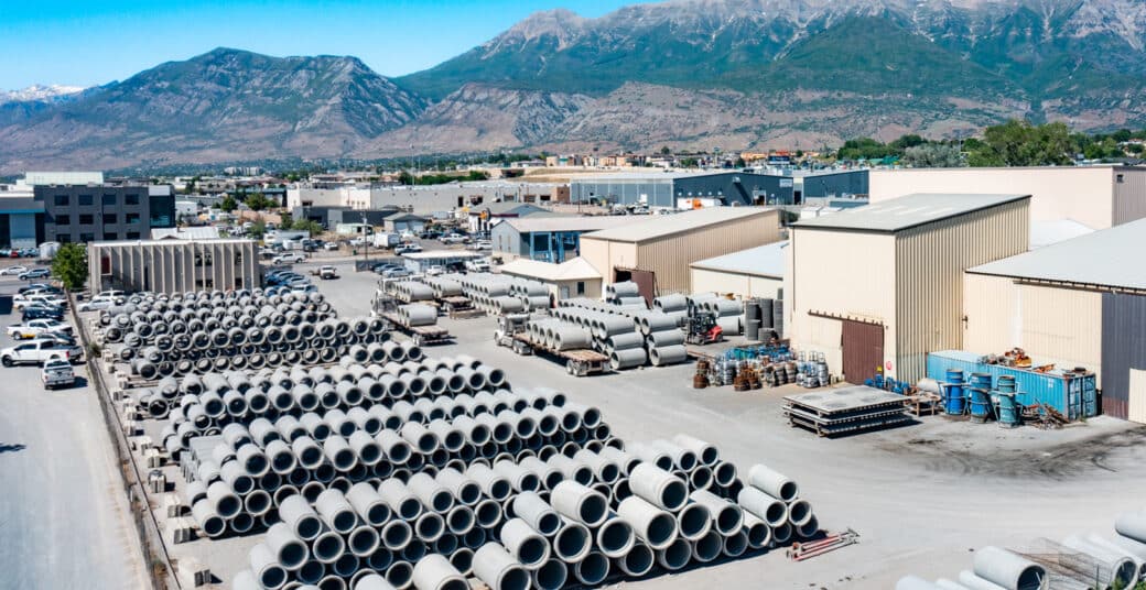 Aerial view of Geneva Pipe and Precast Plant Exterior with stacks of RCP and mountains in background