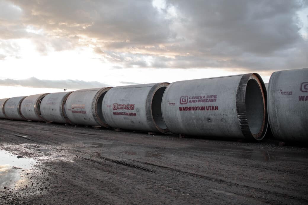 concrete jacking pipe pieces placed in a row on dirt