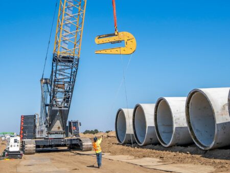 Installing large diameter concrete pipe in in a trench using a crane